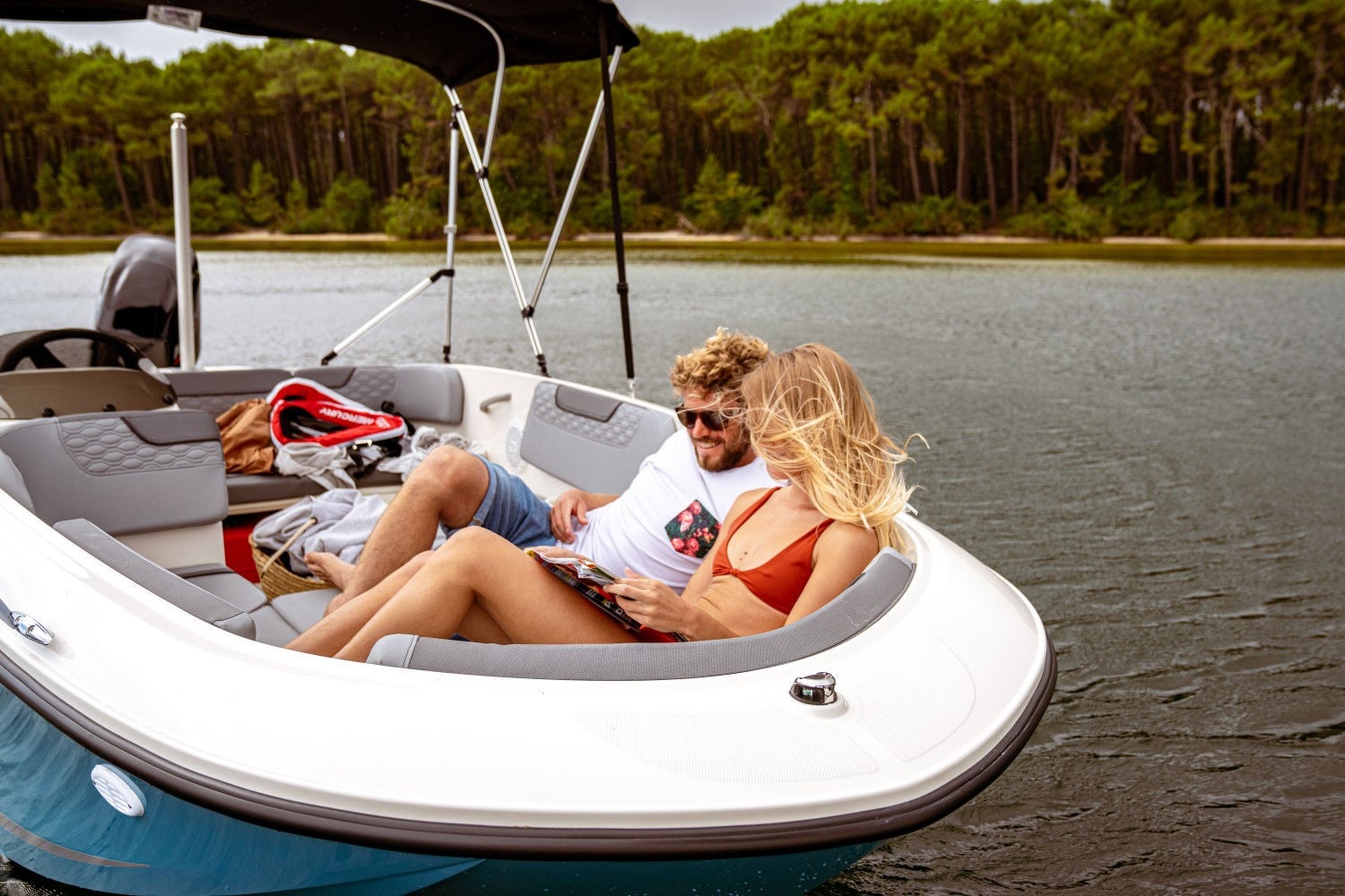 couple sitting in the front of the Element M15 deck boat