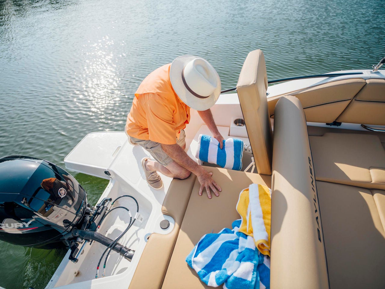 man getting towels from the rear underseat storage on a D22 deck boat