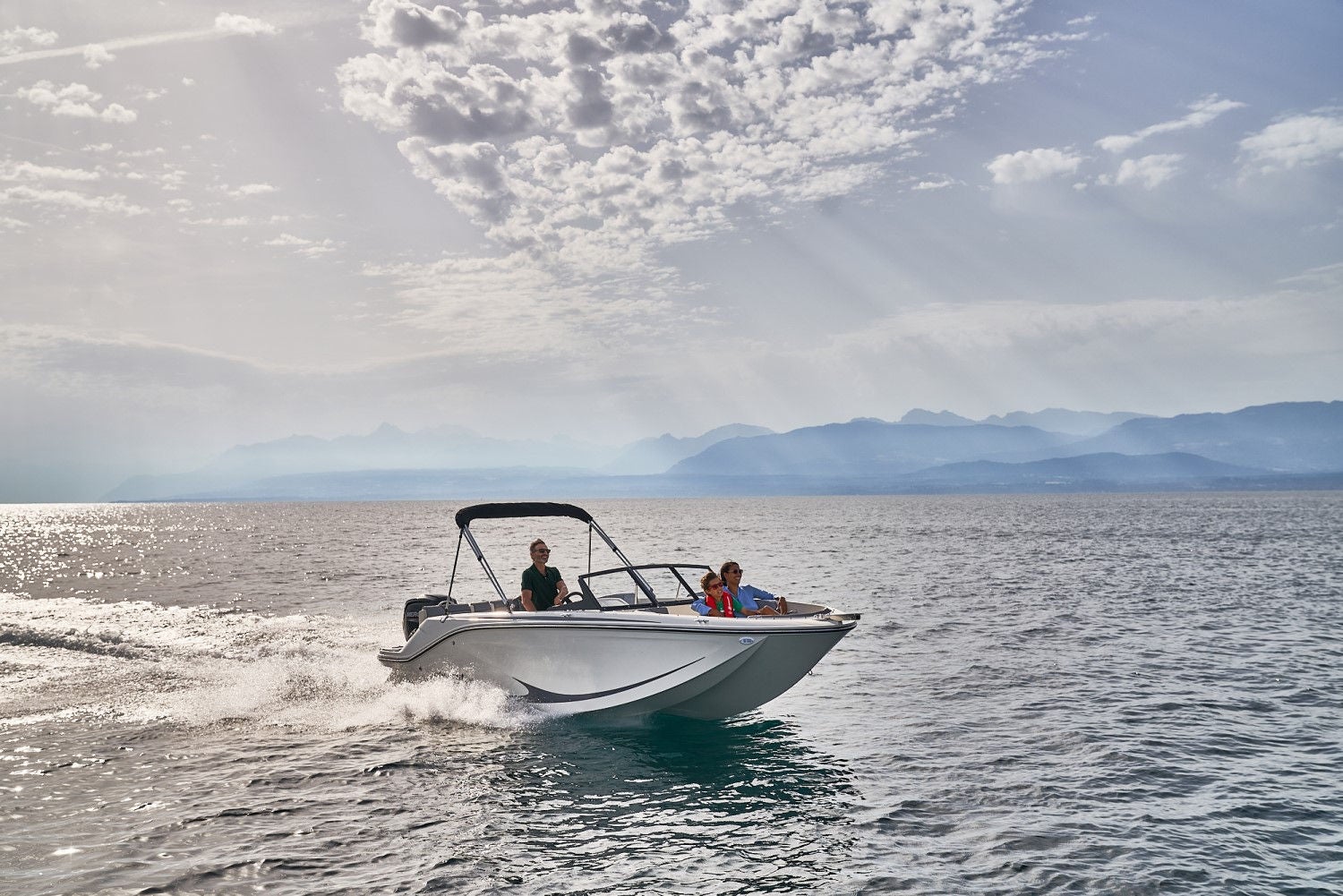 family riding on a white Element M19 deck boat