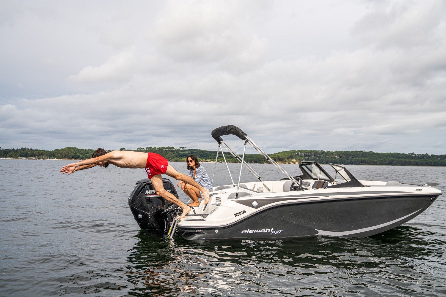 man diving off of the back of an Element M17 deck boat