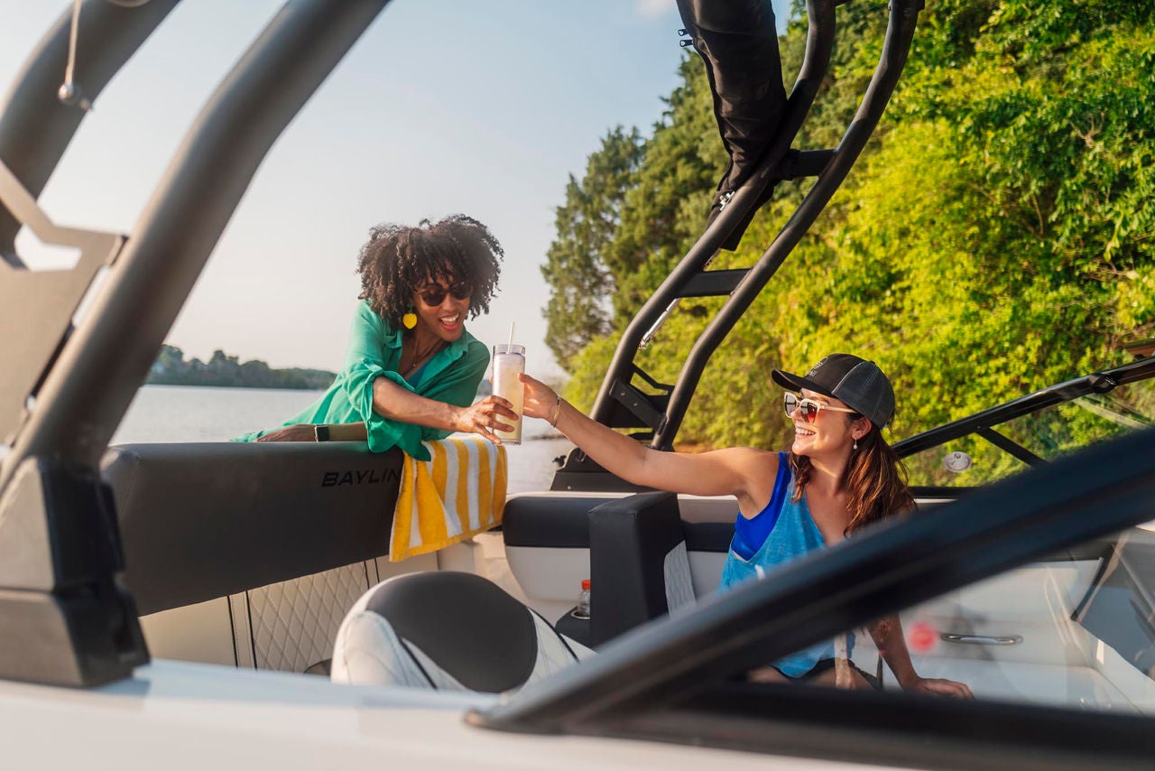two friends enjoy a drink on a D20 deck boat