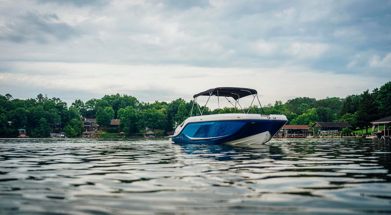 blue D22i deck boat anchored in a lake