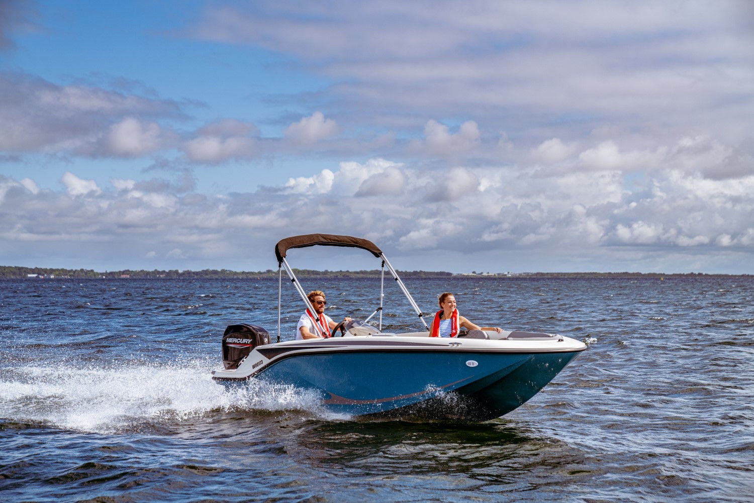couple riding in a blue M15 deck boat