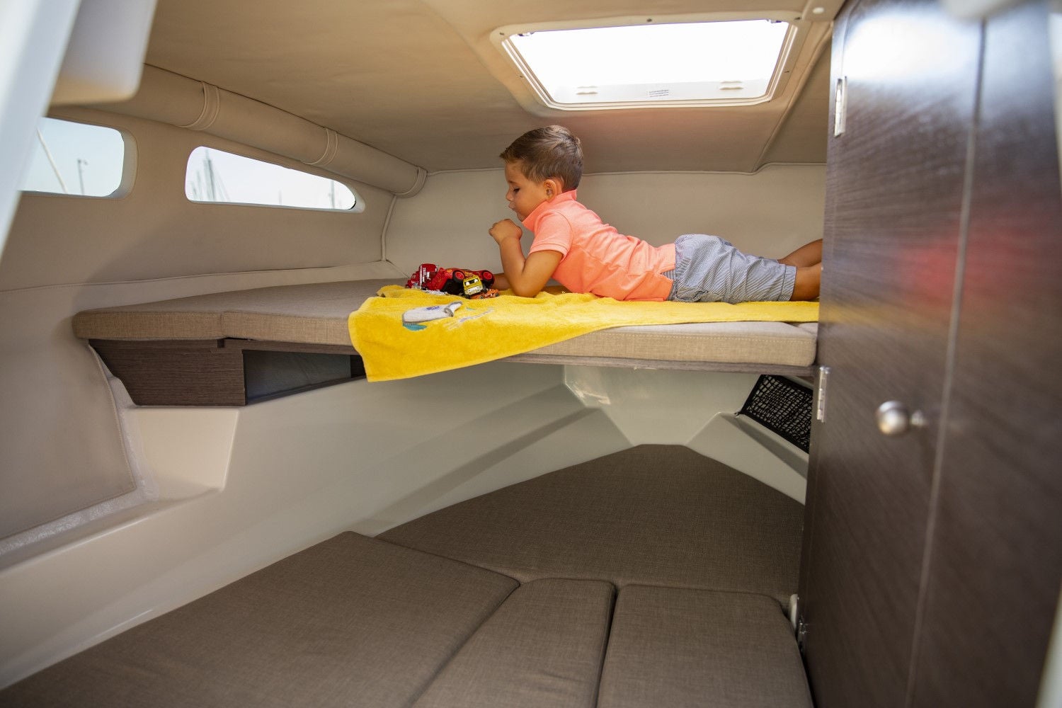 child laying down on the cabin bed aboard the VR6 Cuddy overnight boat
