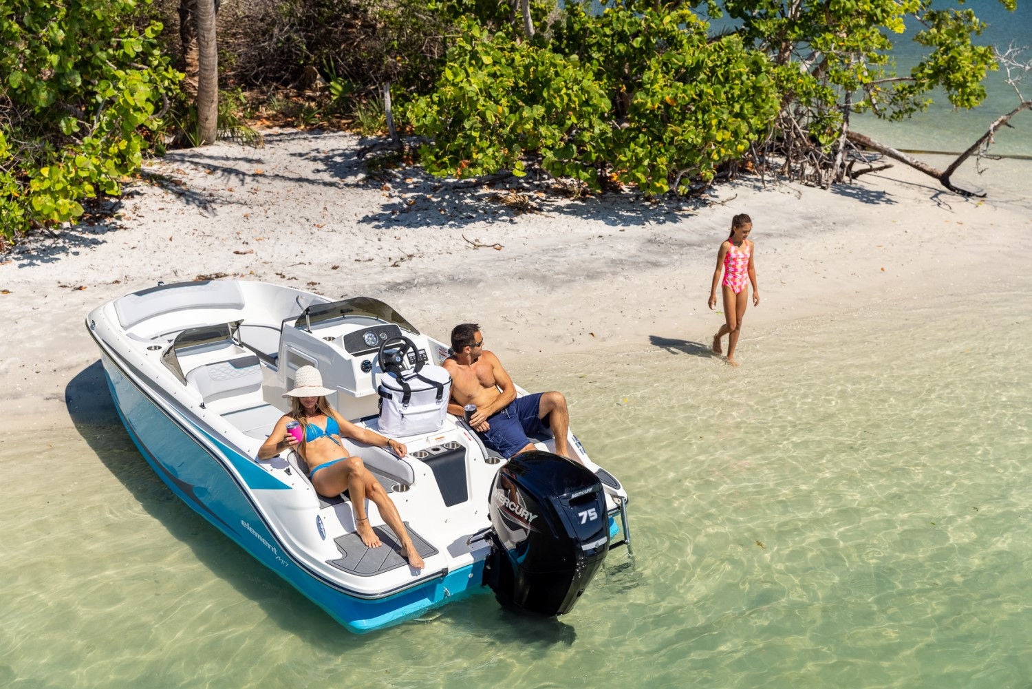 family lounging on an M17 deck boat on a beach