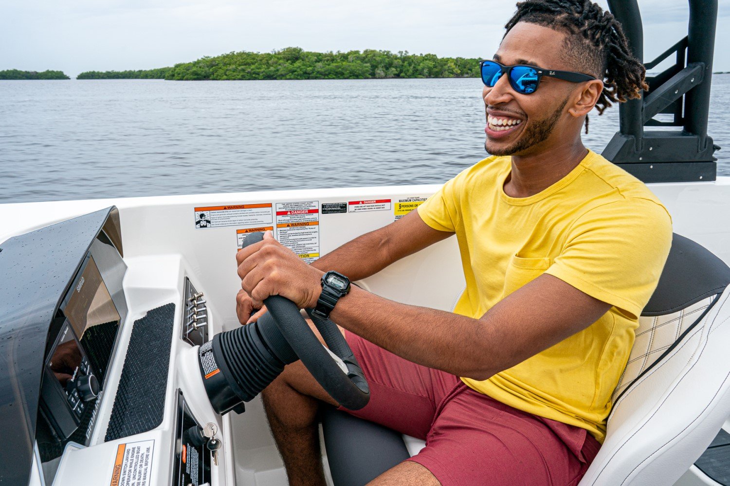 man at the helm of a DX2050 deck boat