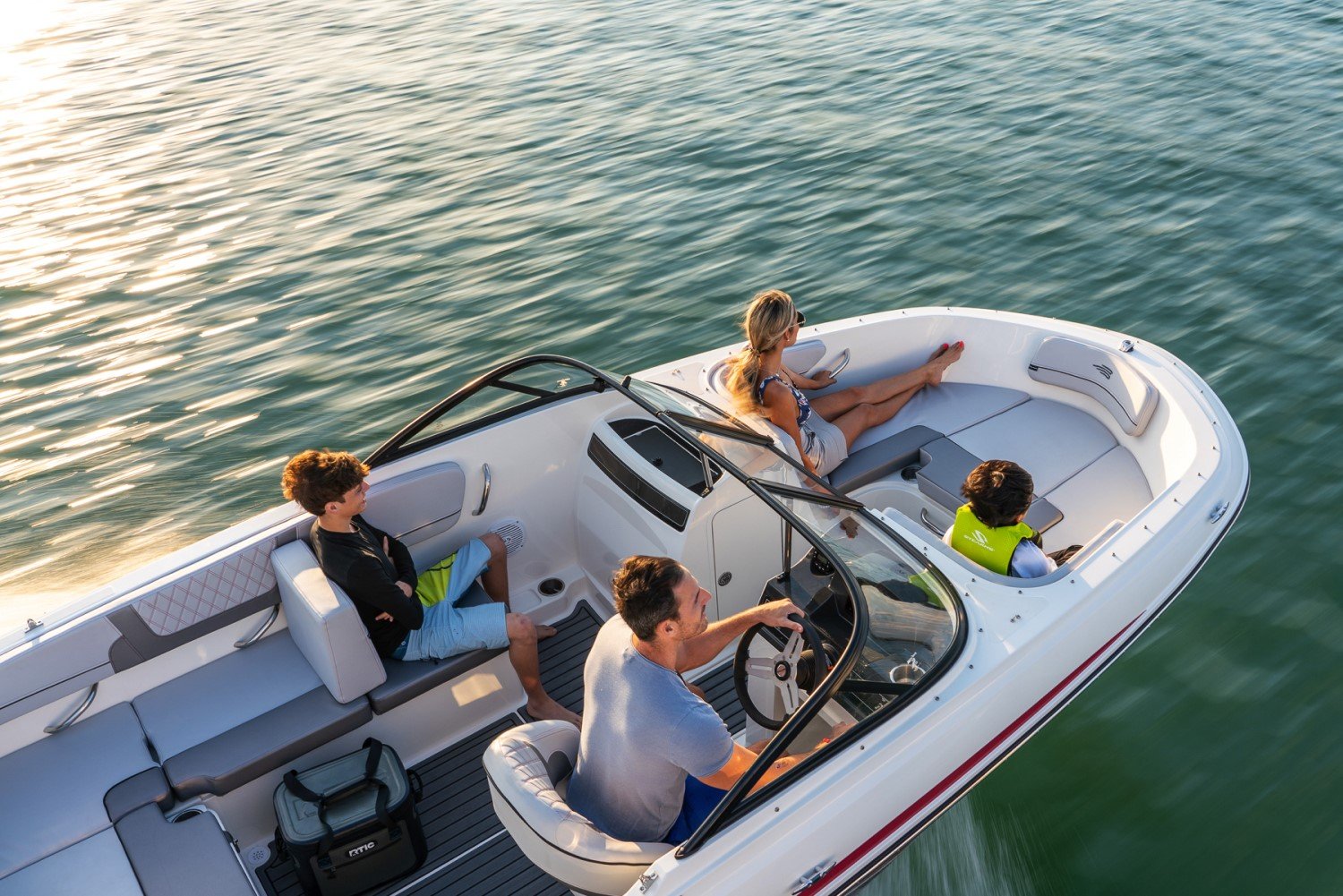 family riding a red VR4 outboard bowrider boat